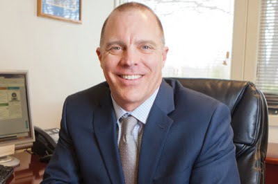 Brian Benner sitting at a desk, smiling